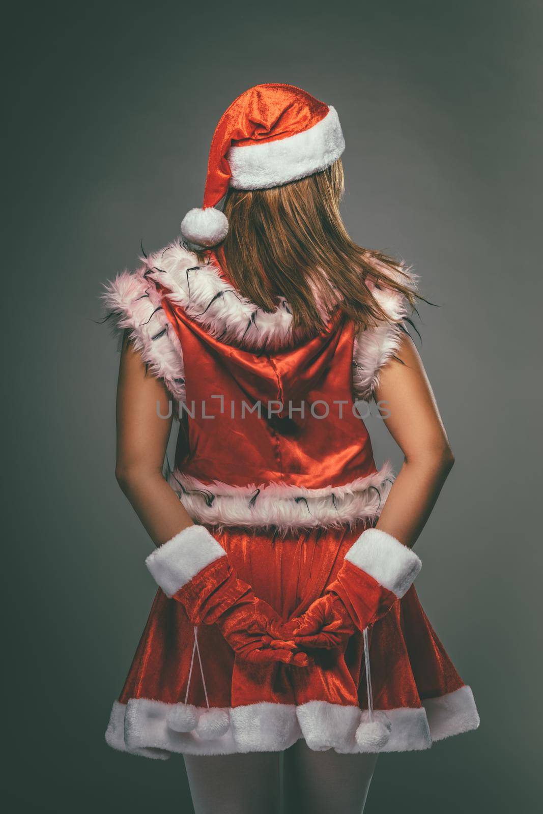Rear view of a beautiful young woman in Santa Claus costume.