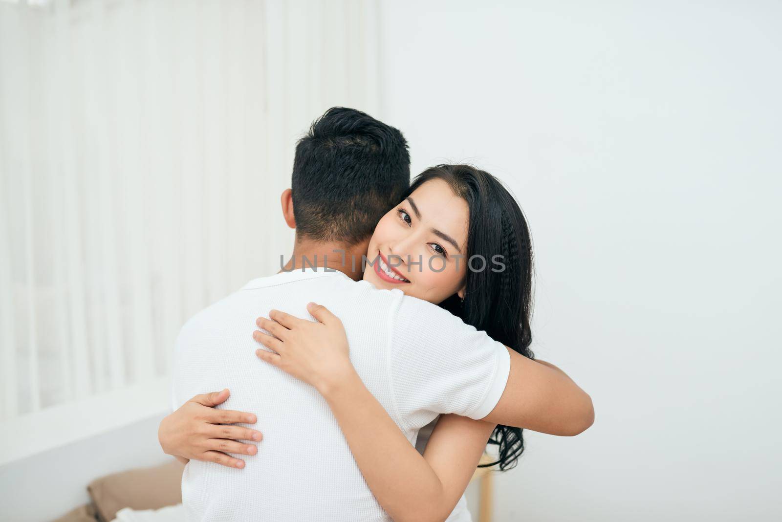 Lovely couple hugging on their bed at home