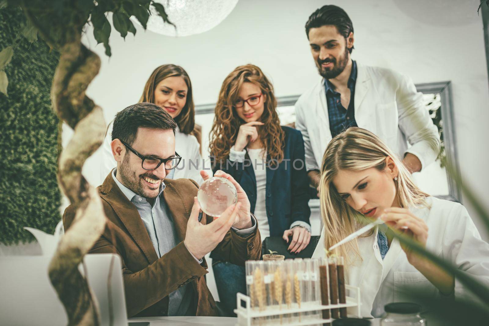 University colleague biologists taking experiment on sprout and checking the analysis of the sample of plant.