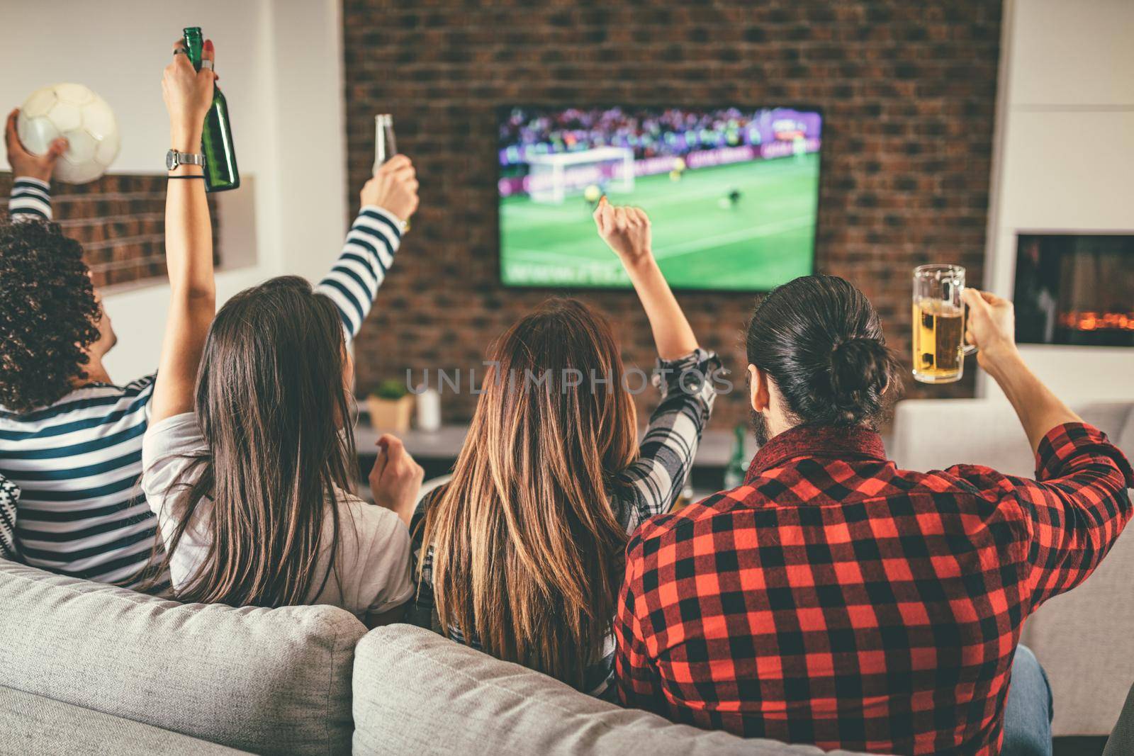 Happy friends or football fans watching soccer on tv and celebrating victory, they looking football on projector, selective focus