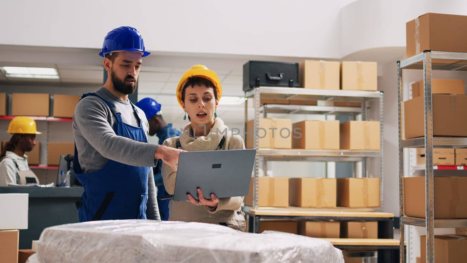 Team of managers planning order distribution on tablet, using list of products to organize on storage room shelves. Young employees discussing about retail goods, manufacturing business.