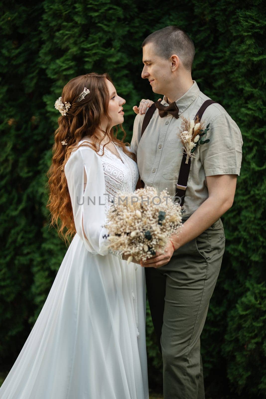 wedding walk of the bride and groom in a coniferous park in summer