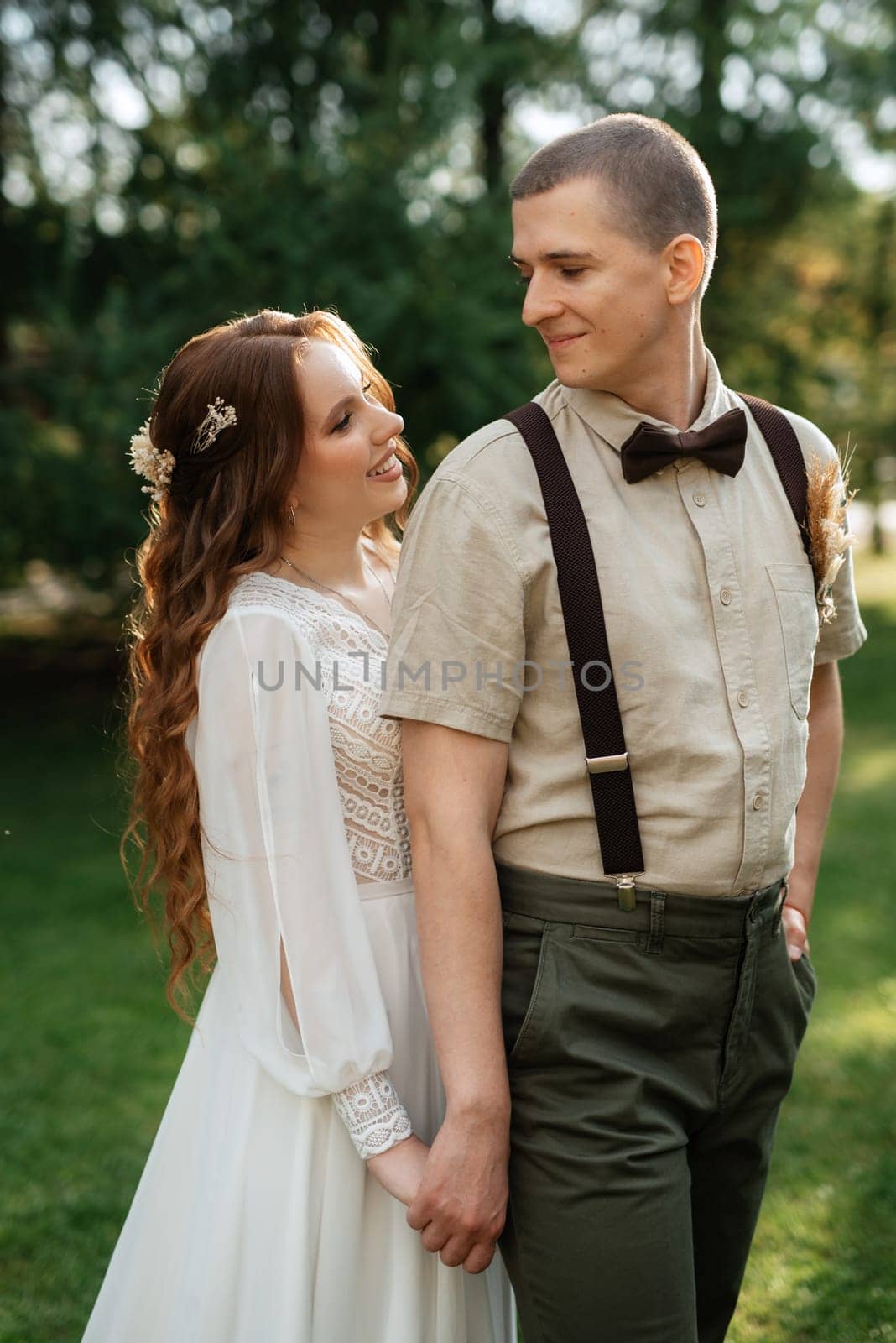 wedding walk of the bride and groom in a coniferous park in summer