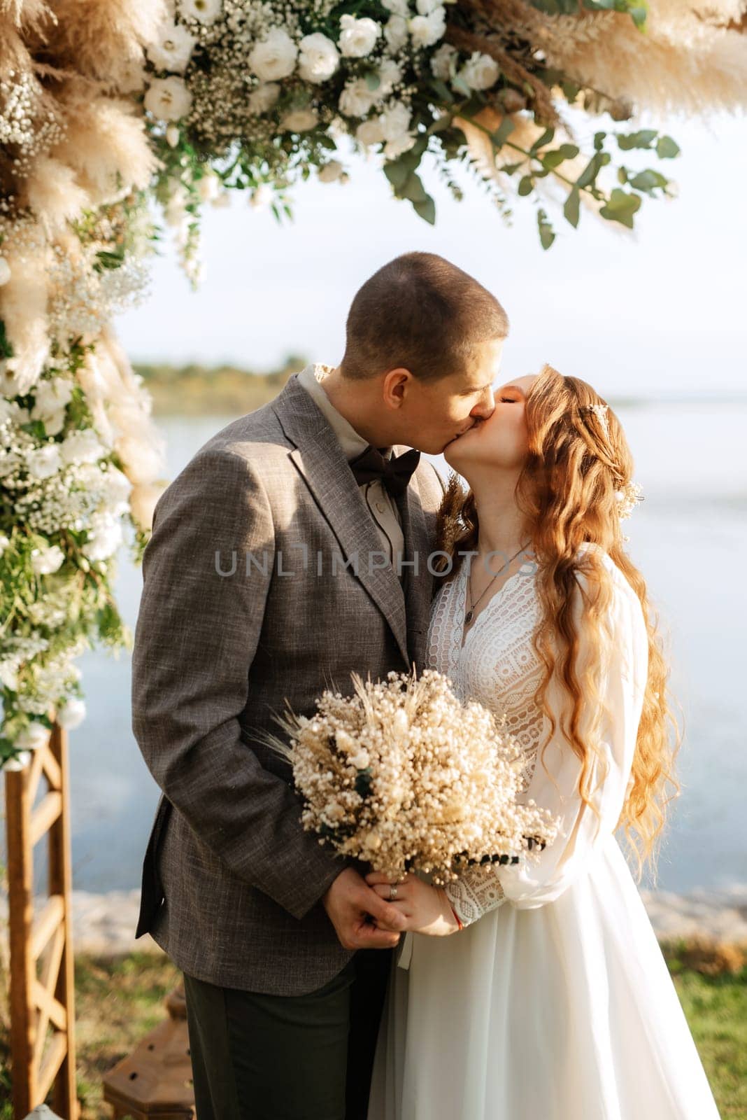 wedding ceremony of the newlyweds in a country cottage on a green hill