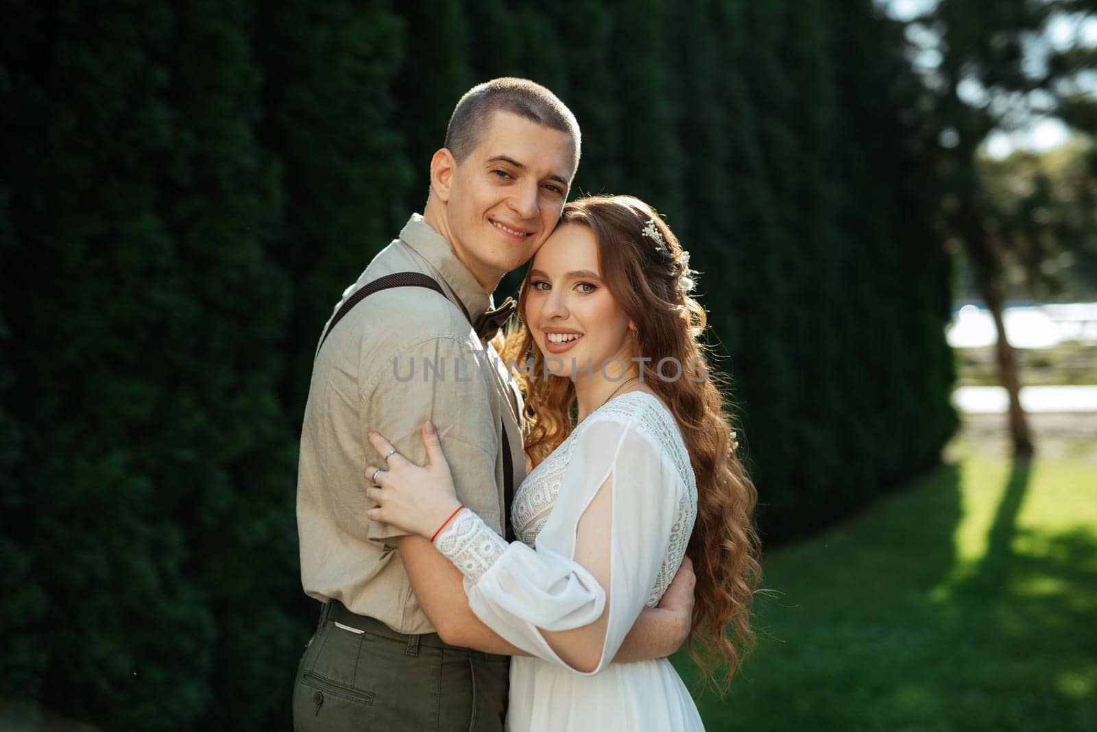 wedding walk of the bride and groom in a coniferous park in summer