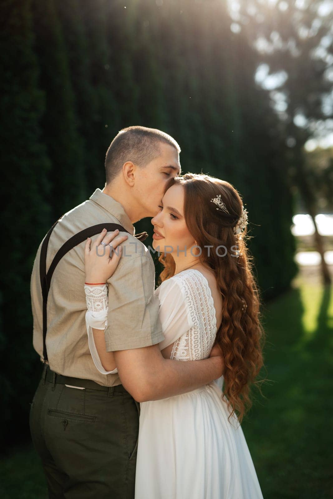 wedding walk of the bride and groom in a coniferous park in summer