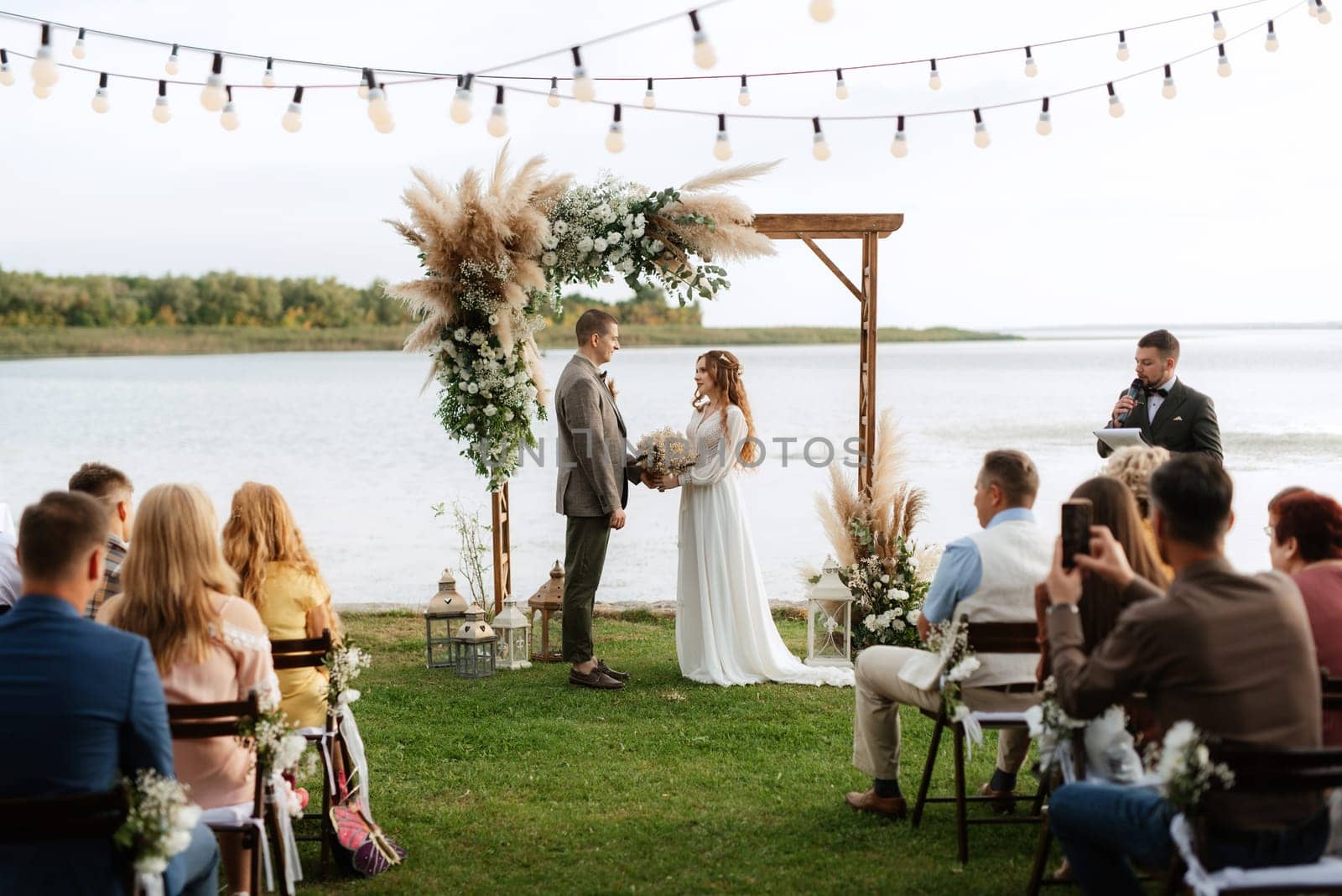 wedding ceremony of the newlyweds in a country cottage on a green hill