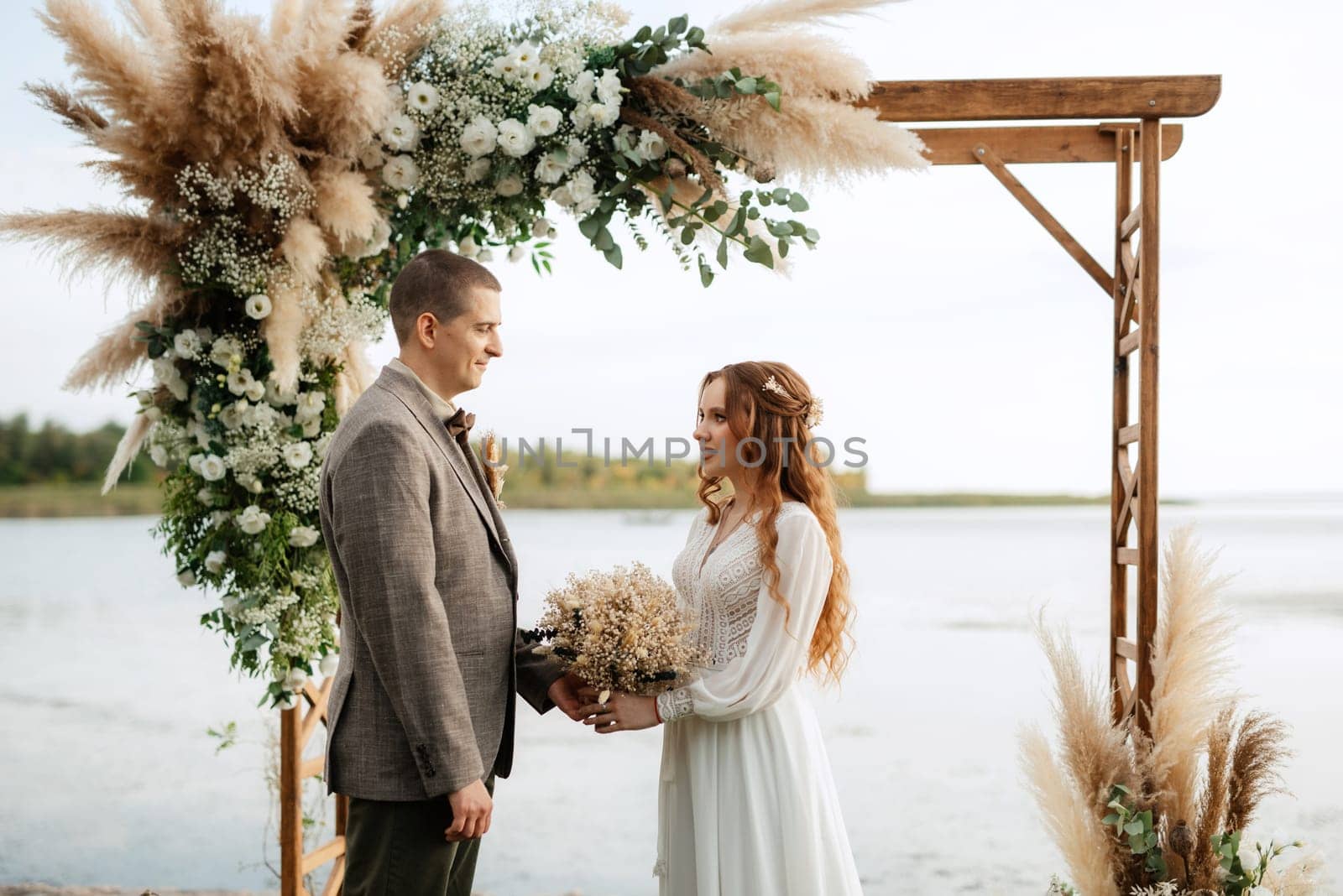 wedding ceremony of the newlyweds in a country cottage on a green hill