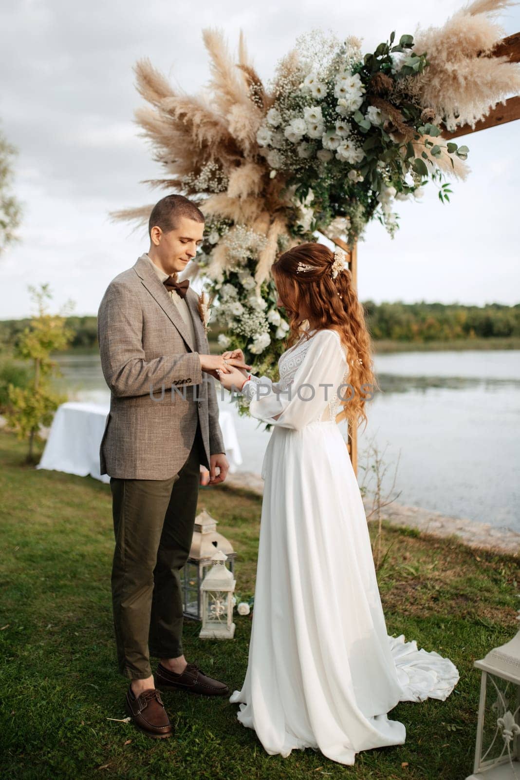 wedding ceremony of the newlyweds in a country cottage on a green hill