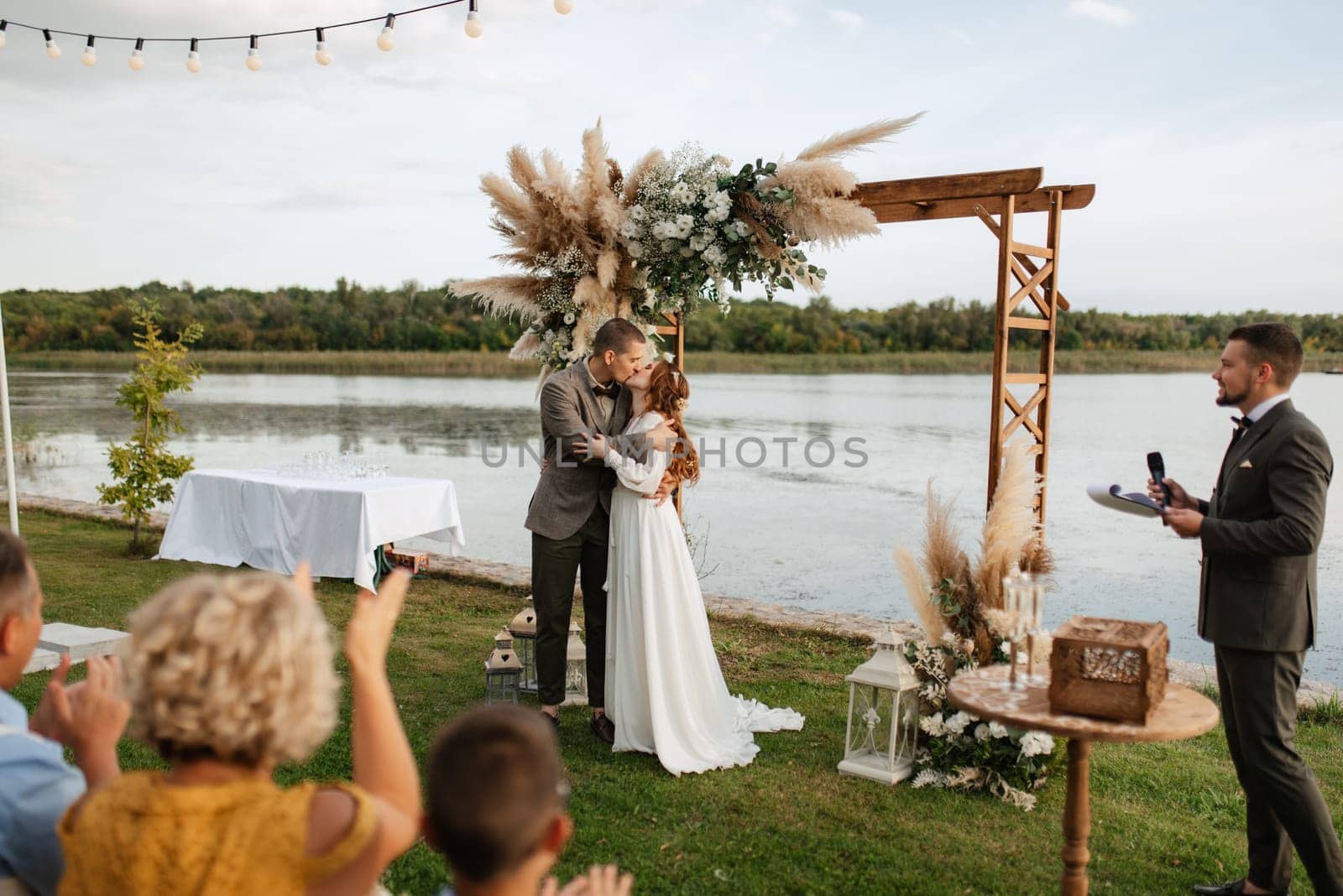 wedding ceremony of the newlyweds in a country cottage on a green hill