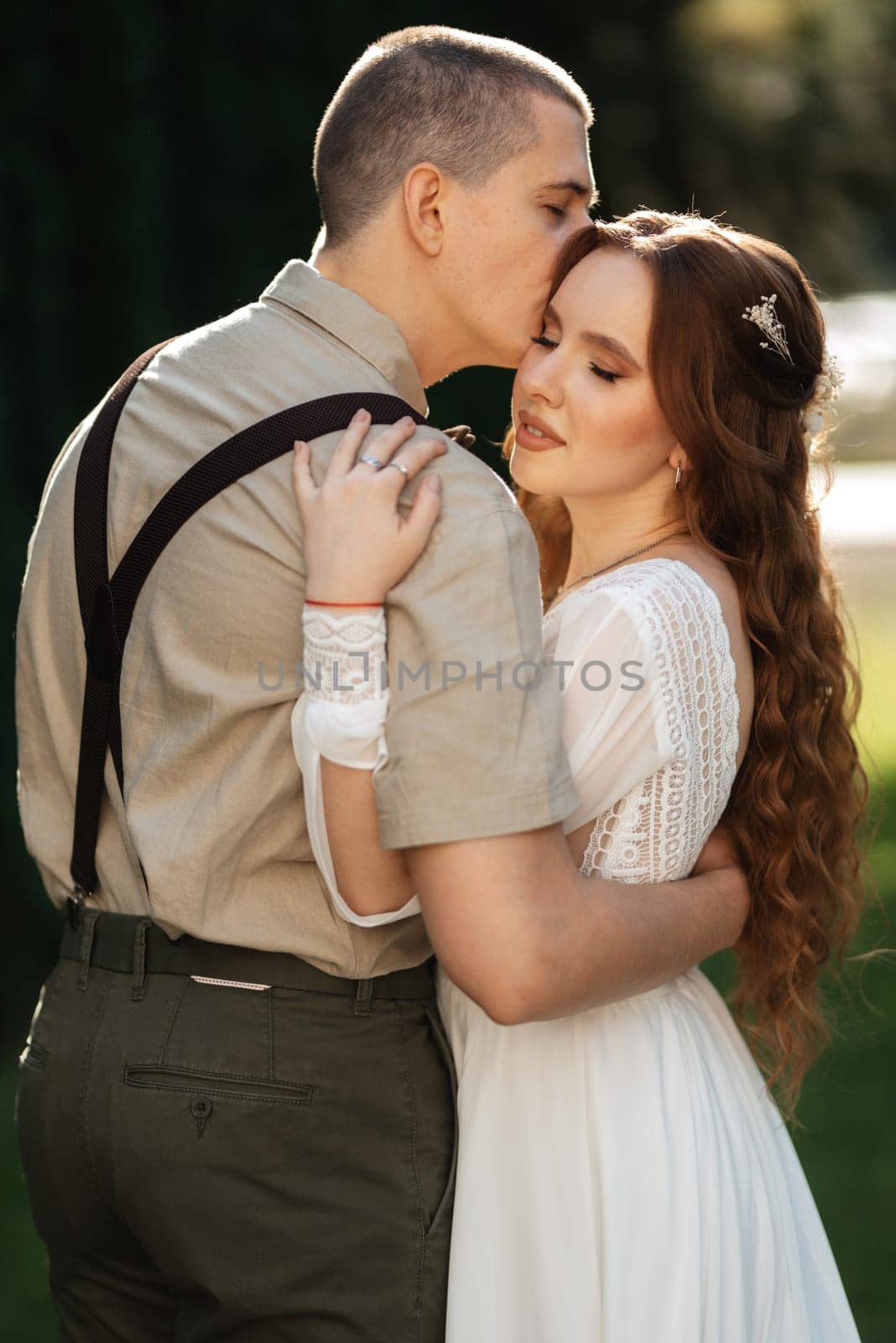 wedding walk of the bride and groom in a coniferous park in summer