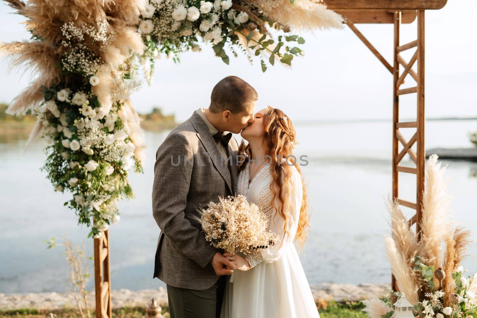 wedding ceremony of the newlyweds in a country cottage on a green hill