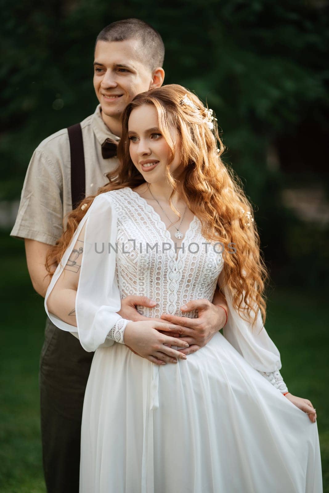 wedding walk of the bride and groom in a coniferous park in summer