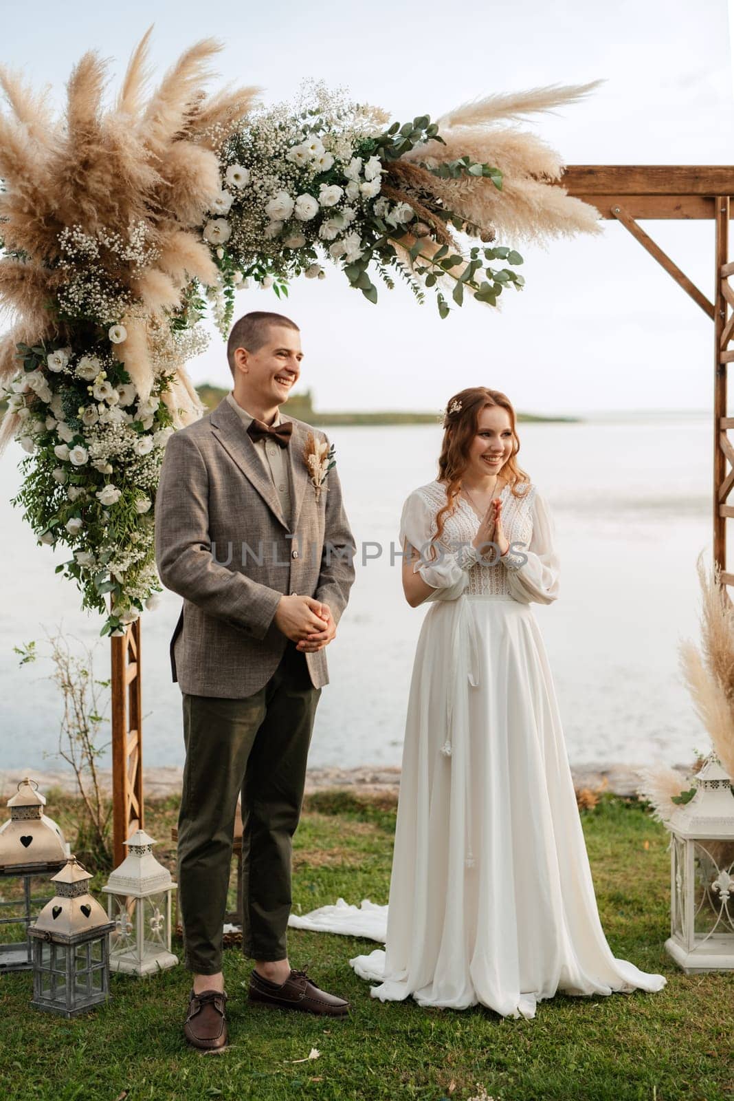 wedding ceremony of the newlyweds in a country cottage on a green hill