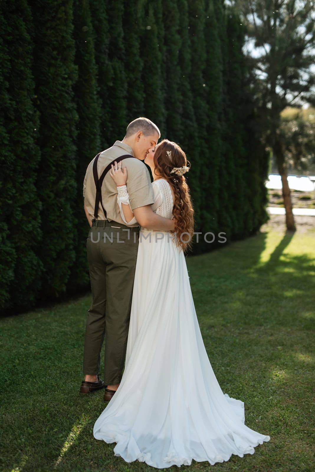 wedding walk of the bride and groom in a coniferous park in summer