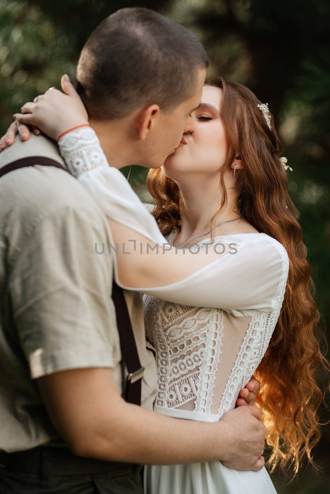 wedding walk of the bride and groom in a coniferous park in summer