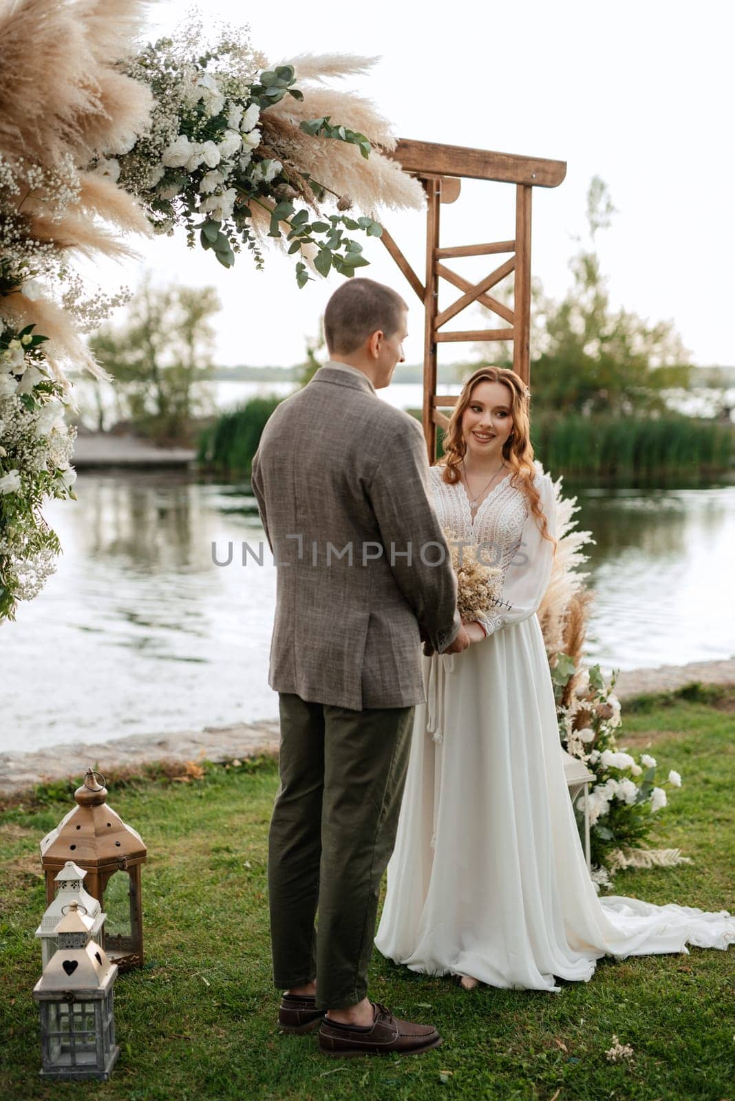 wedding ceremony of the newlyweds in a country cottage on a green hill