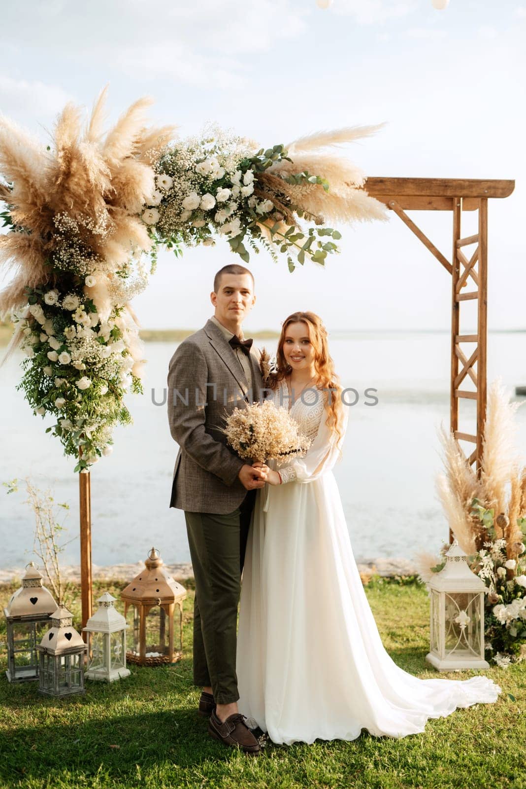 wedding ceremony of the newlyweds in a country cottage on a green hill