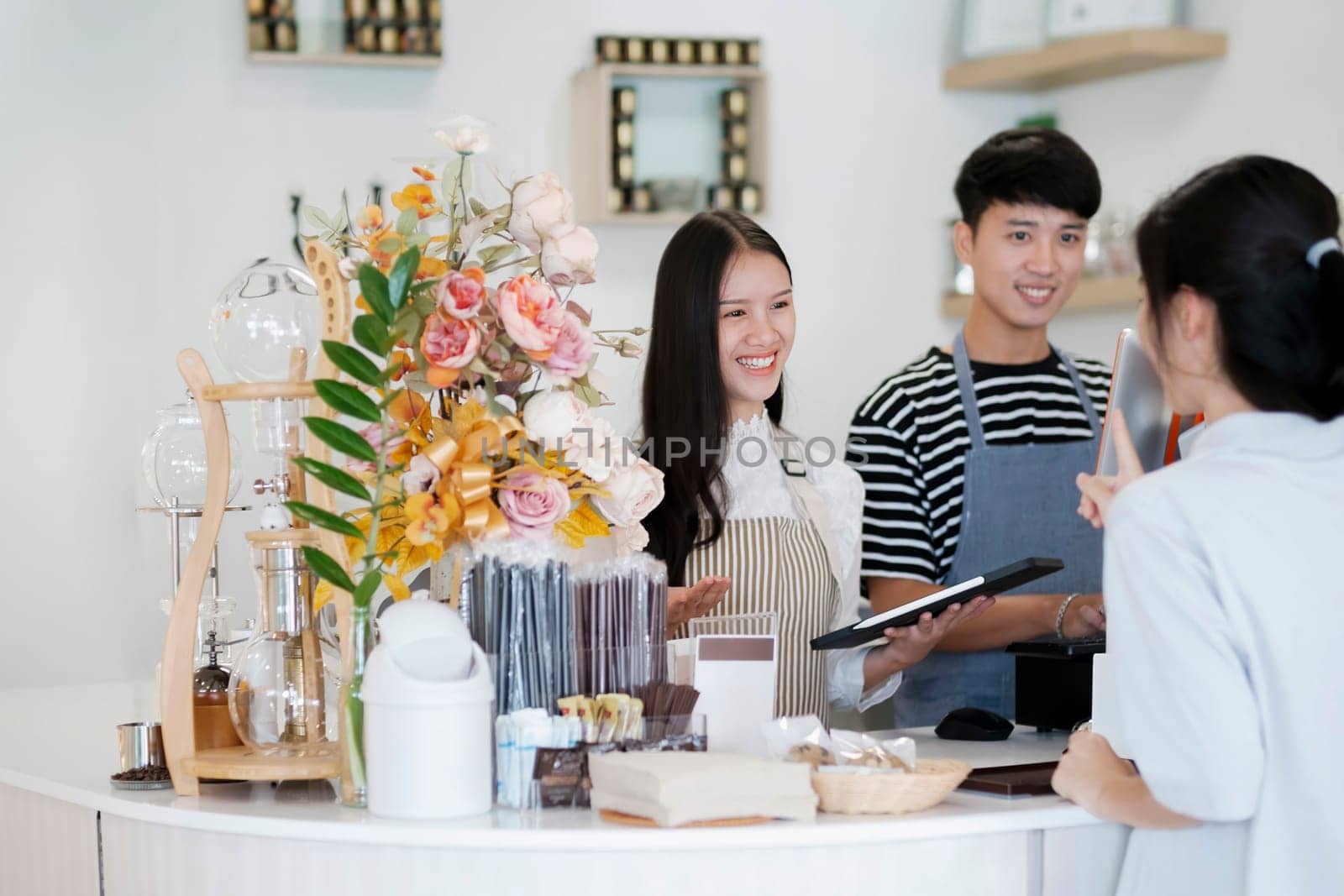 Asia Barista waiter take order from customer in coffee shop, cafe owner writing drink order at counter bar. by ijeab
