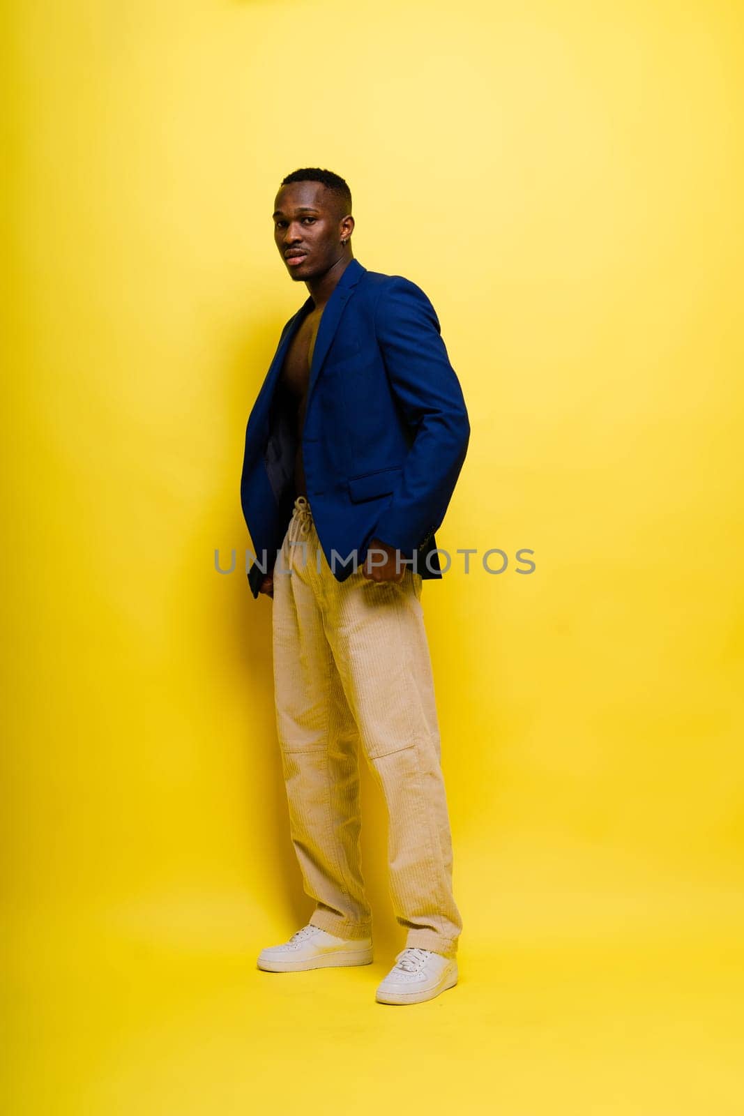 Laughing single handsome young African man over red yellow background with copy space by Zelenin