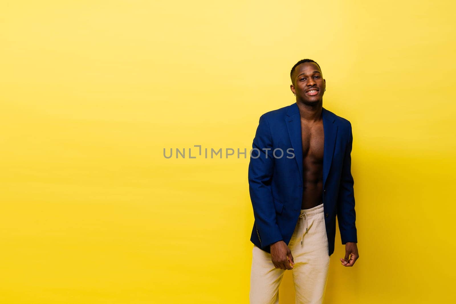 Laughing single handsome young African man over a red yellow background with copy space