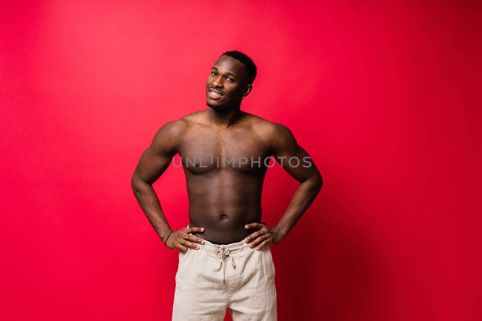 Laughing single handsome young African man over a red yellow background with copy space