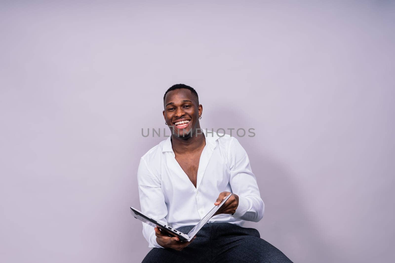 Laughing single handsome young African man over a red yellow background with copy space