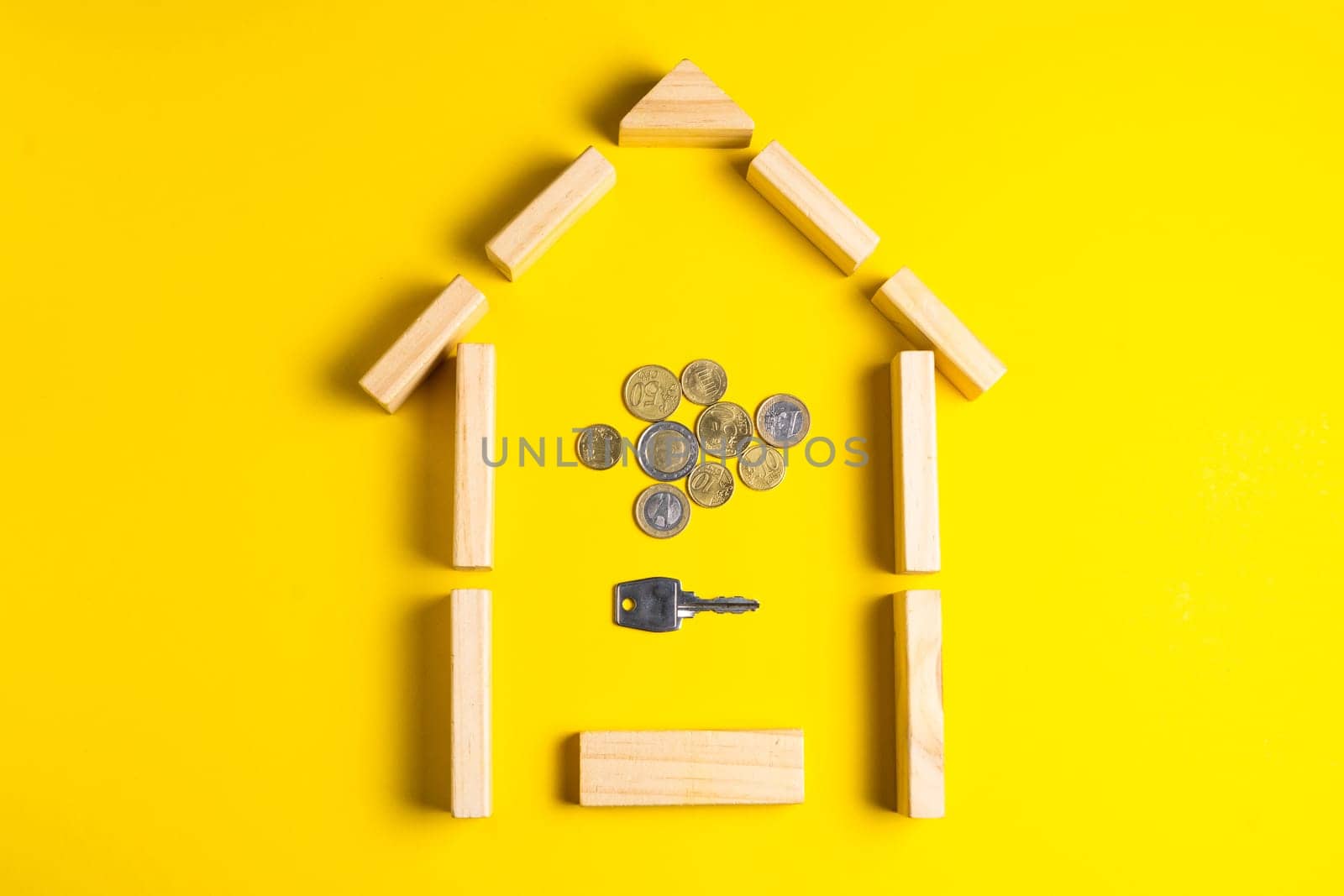 Wooden house model with coins, money, copy space on yellow background. by Zelenin