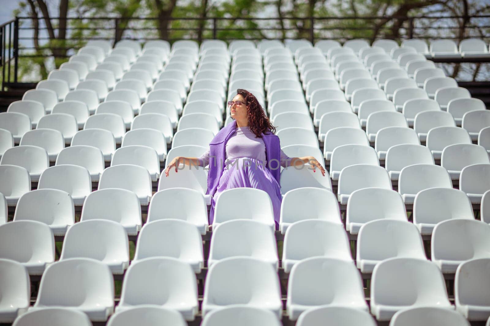 Woman Seats of tribune on sport stadium. Concept of fans, chairs for audience, cultural environment concept. mpty seats, modern stadium