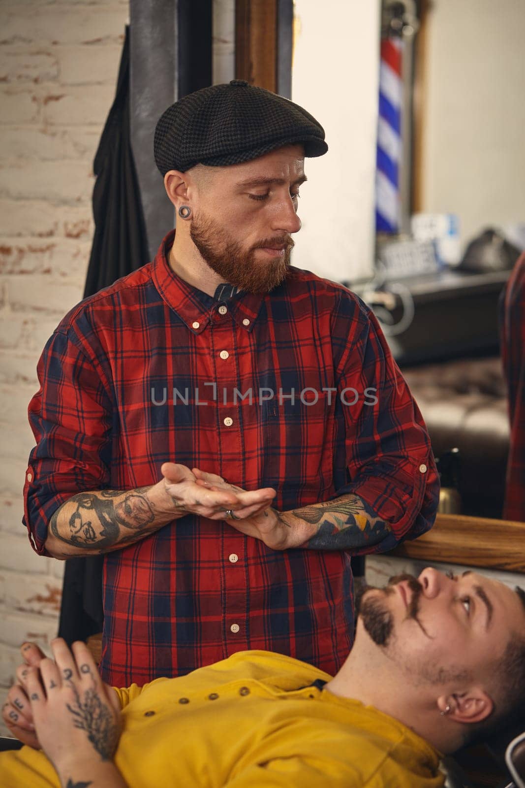 Client during beard shaving in barber shop by nazarovsergey