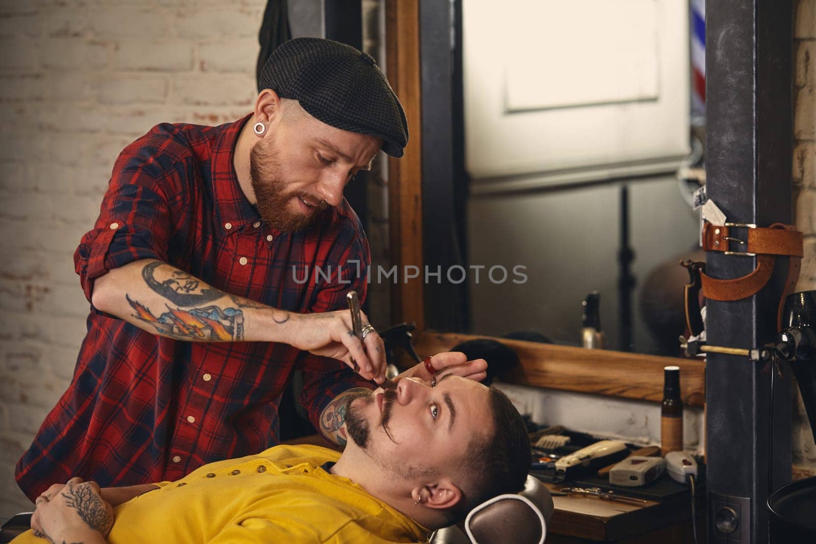 Client during beard shaving in barber shop by nazarovsergey