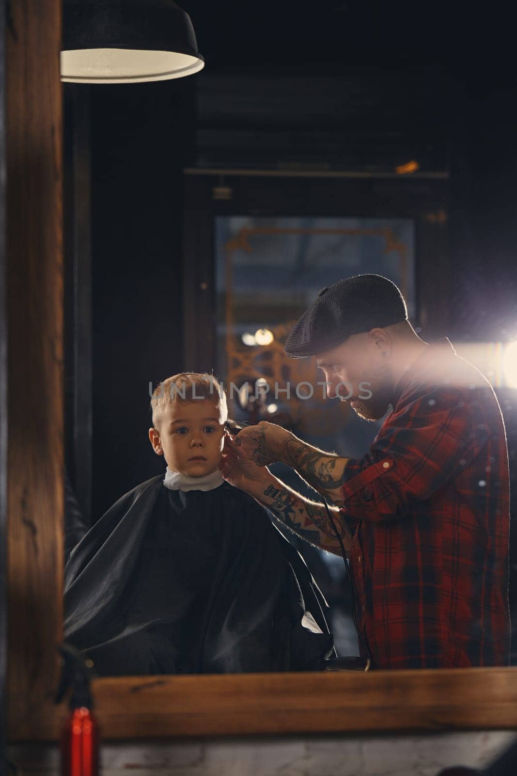 Caucasian boy getting haircut in barbershop indoor by nazarovsergey