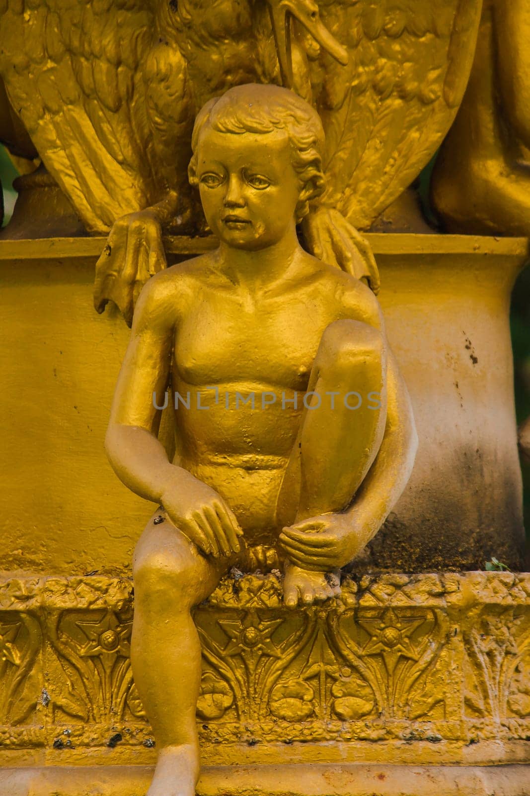 Golden boy statue on the fountain in the park