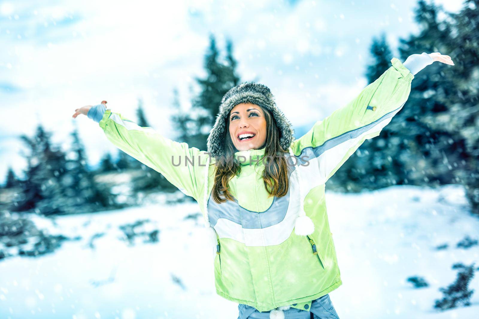 Beautiful cheerful young woman enjoying in ski vacations and sunny winter day. 