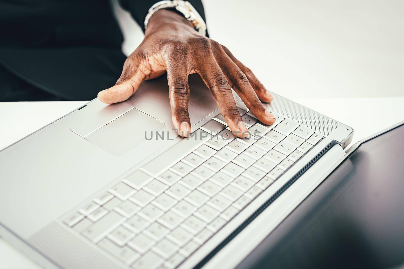 Close-up of male African hand on the keyboard of the laptop.