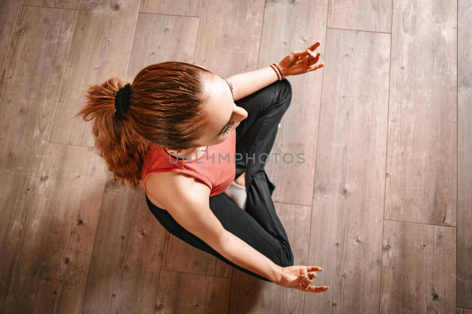 Beautiful young woman doing yoga at her living room.