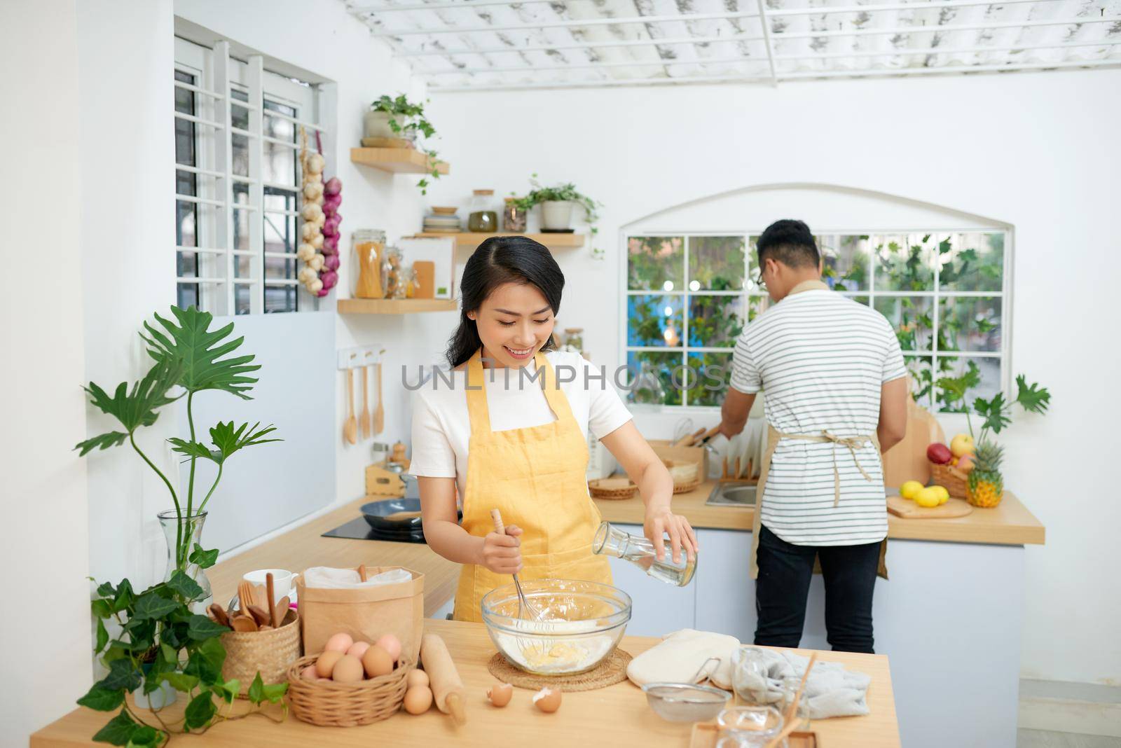 Couple cooking bakery in kitchen room, Young asian man and woman together making cake and bread with egg, by makidotvn