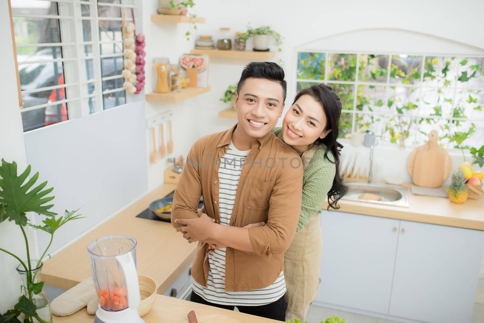 young asian couple cooking in kitchen