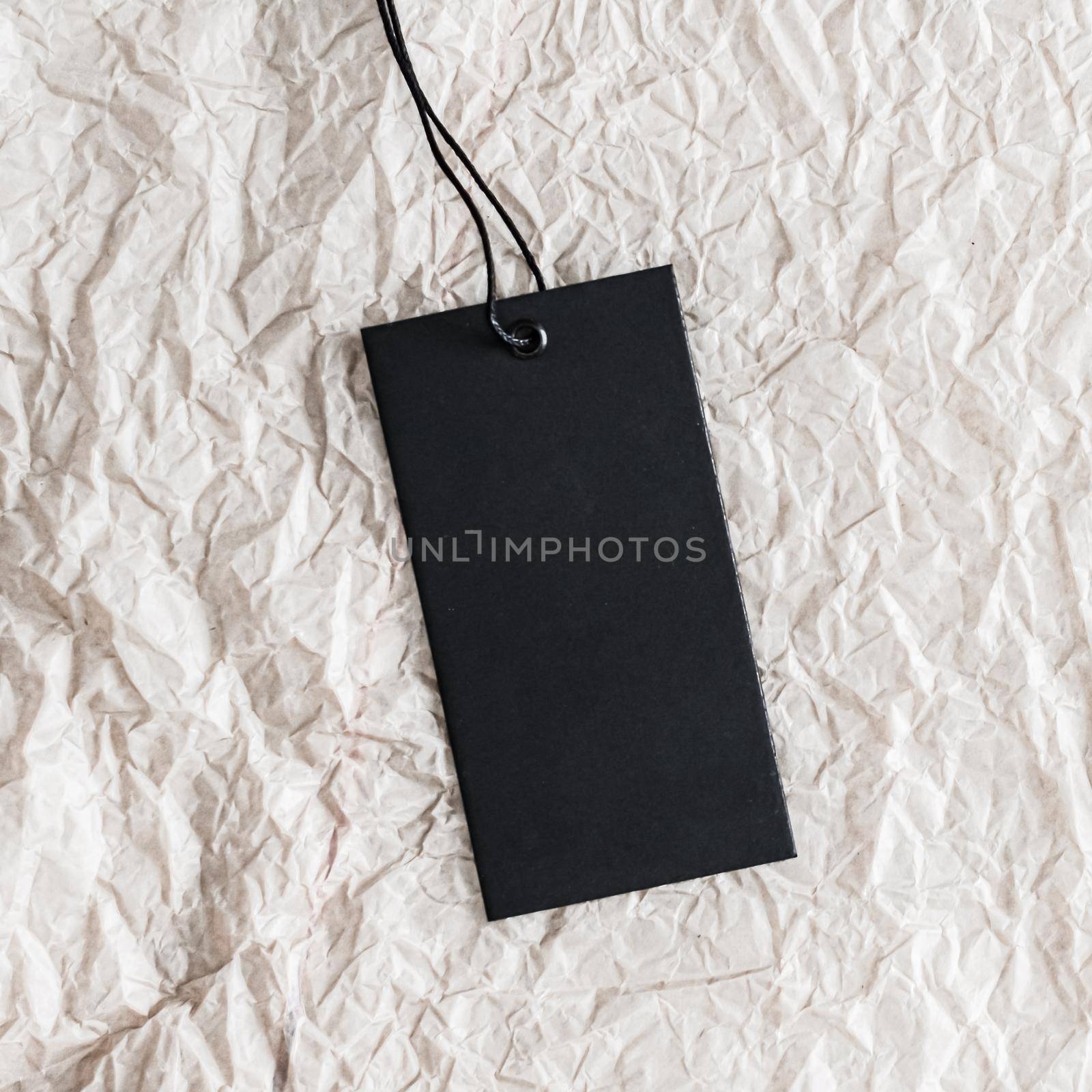 Vertical black clothing tag on white paper as eco-friendly, organic material background, sustainable fashion and brand label concept by Anneleven