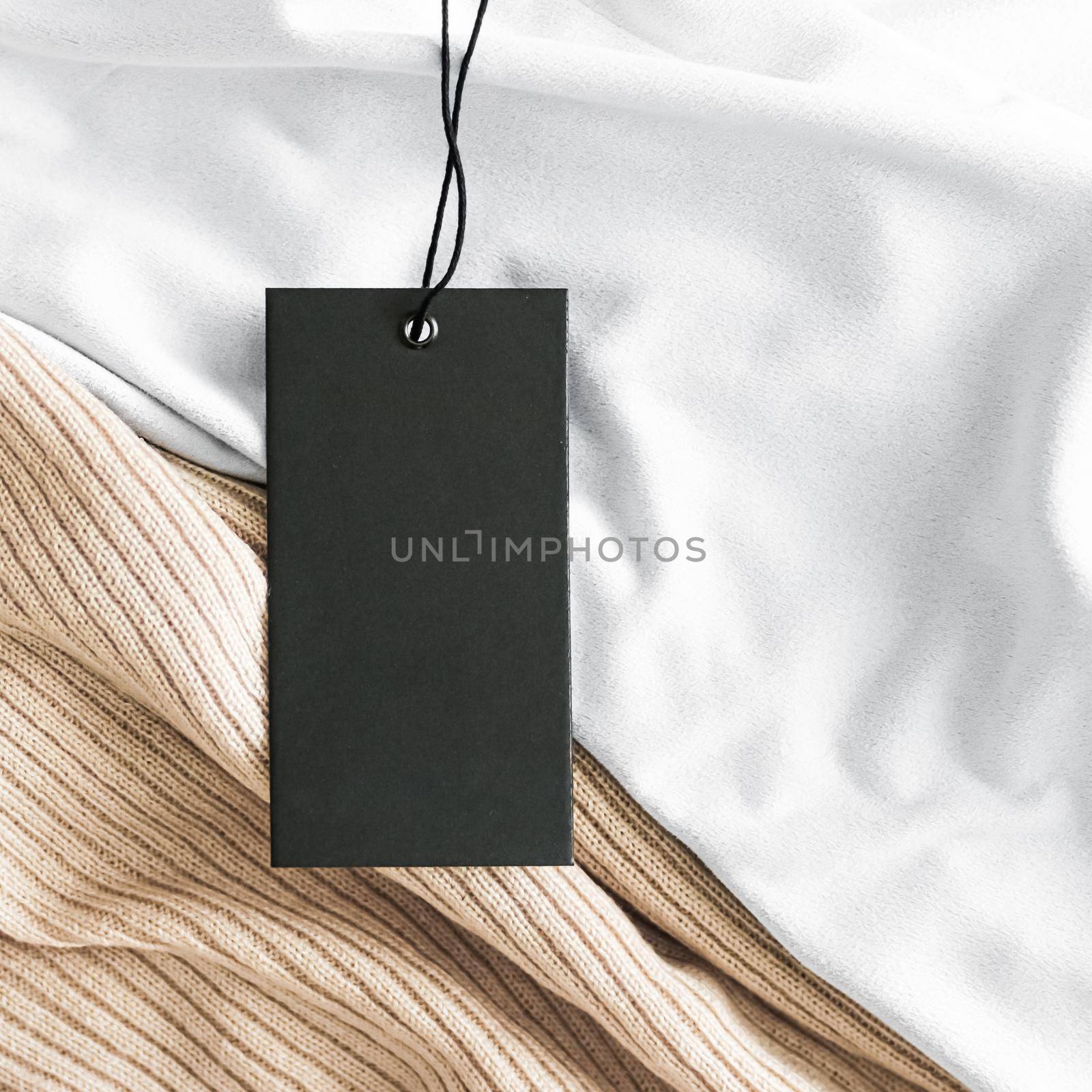 Clothing tag on luxury organic fabric background, sustainable fashion and brand label concept by Anneleven