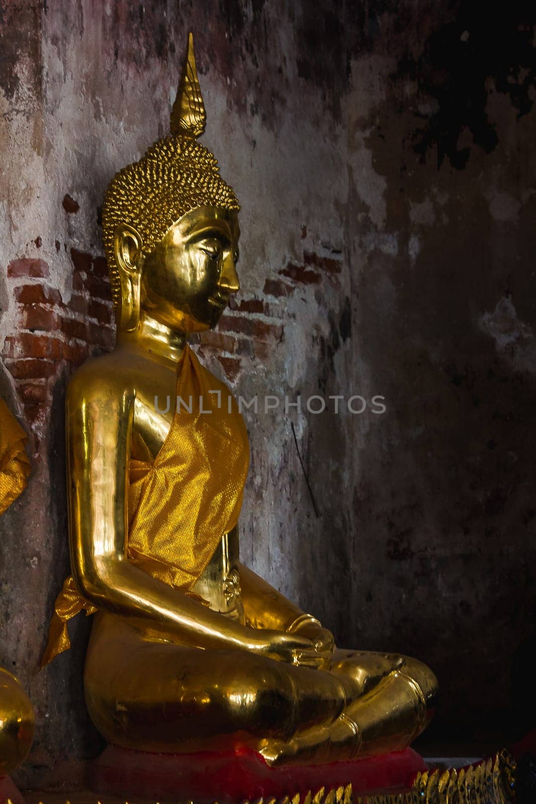 Golden Buddha beside old walls in Thai temples