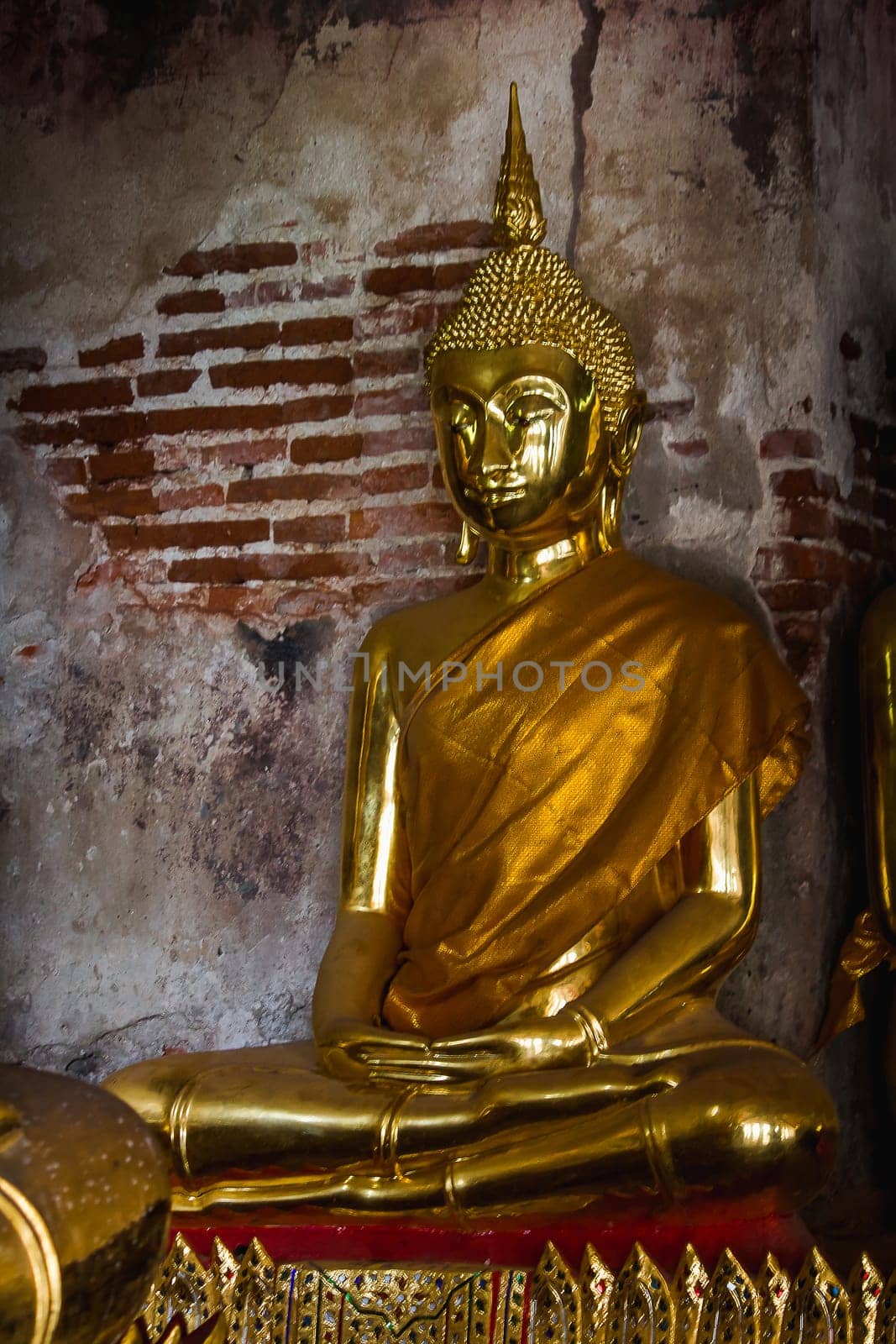 Golden Buddha beside old walls in Thai temples