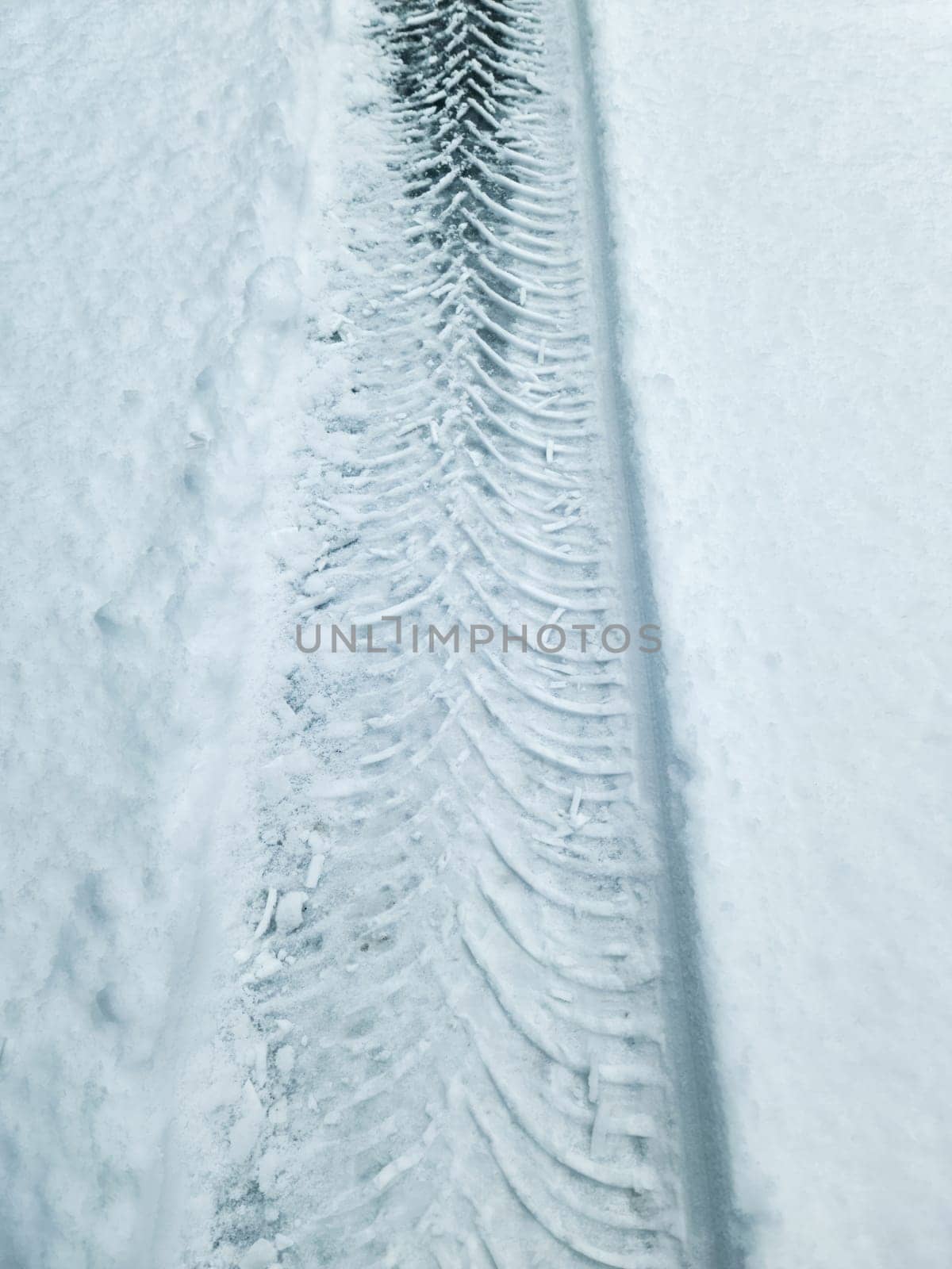 Tire Tracks on snow covered streets in a close up view. by MP_foto71
