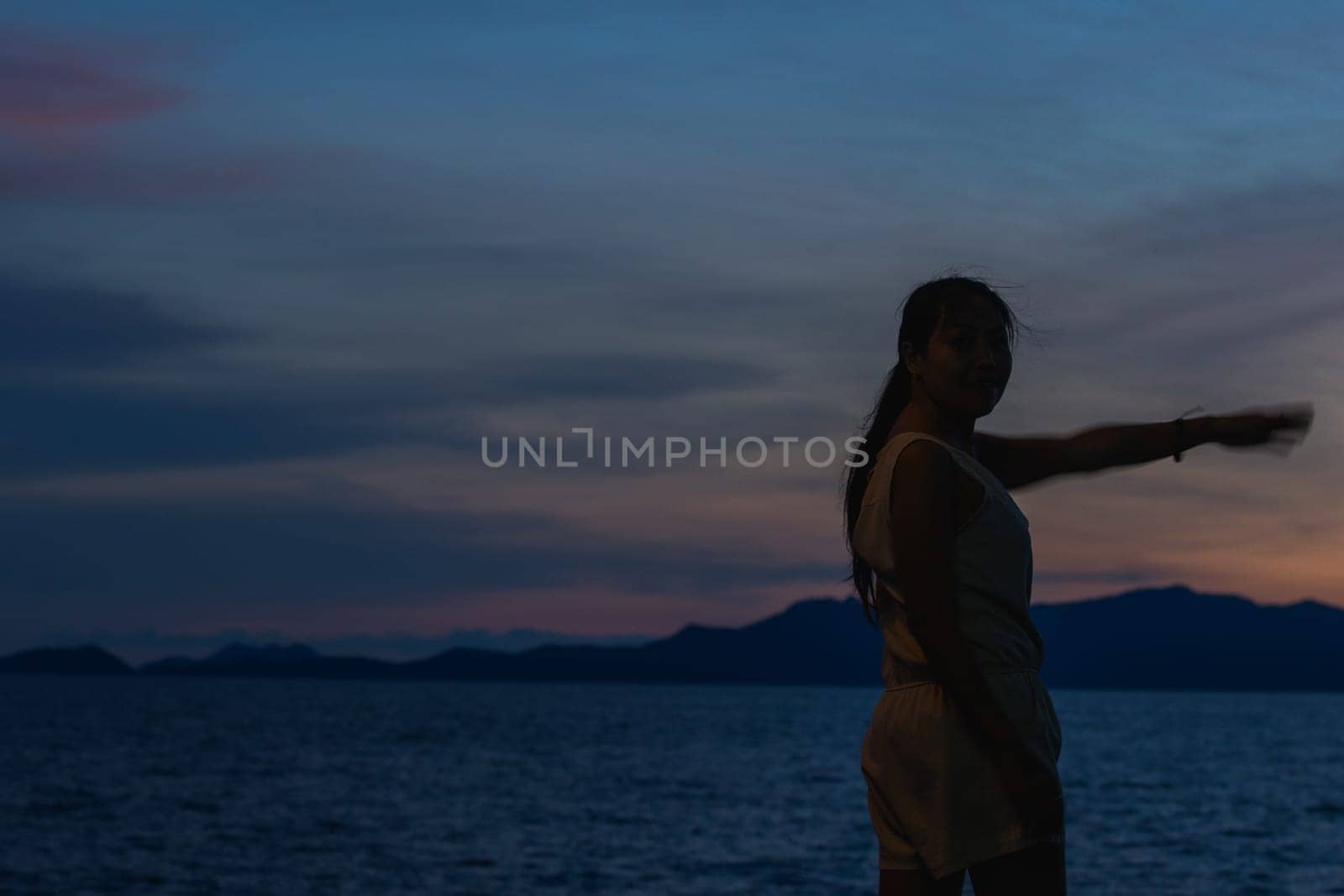 Silhouette of a woman standing and watching the sunset