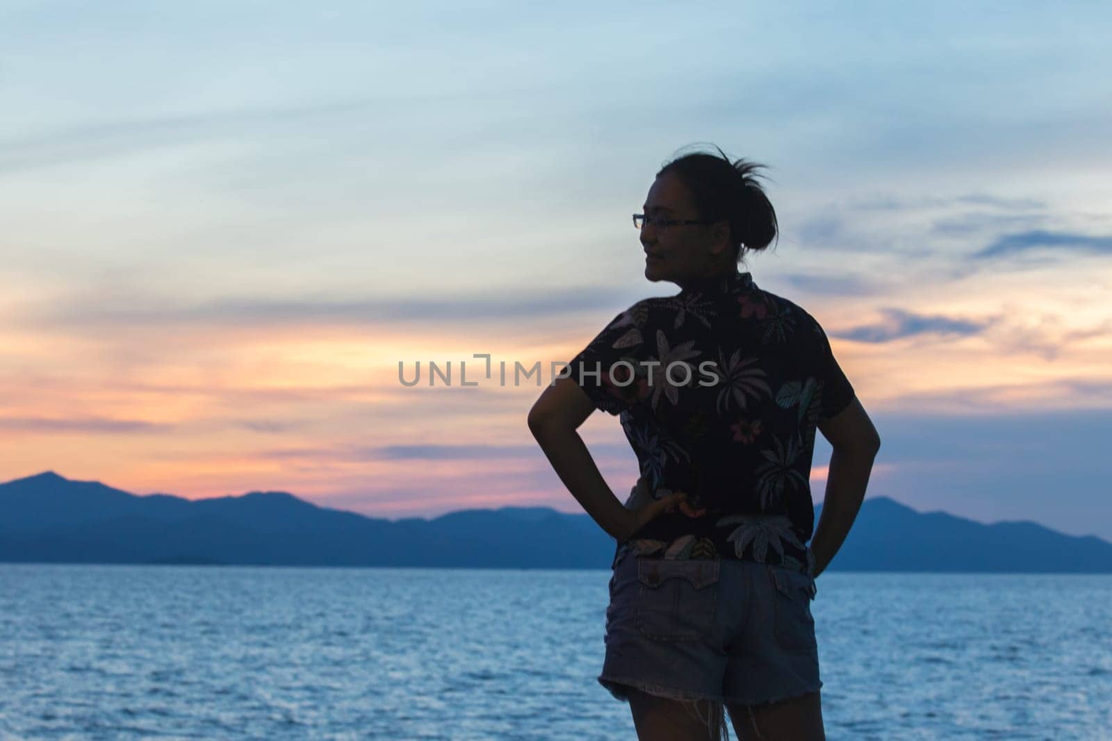 Silhouette of a woman standing and watching the sunset