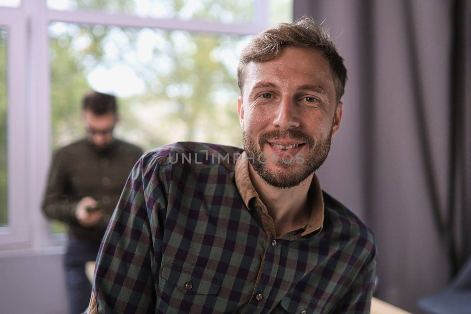 portrait smiling confident businessman standing in modern office room with arms crossed, diverse colleagues on background by asdf