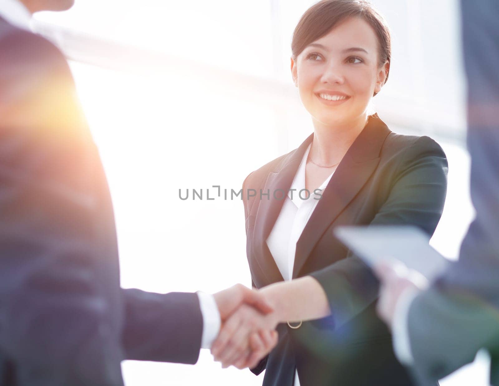 Businesswoman shaking hands with a businssman during a meeting by asdf