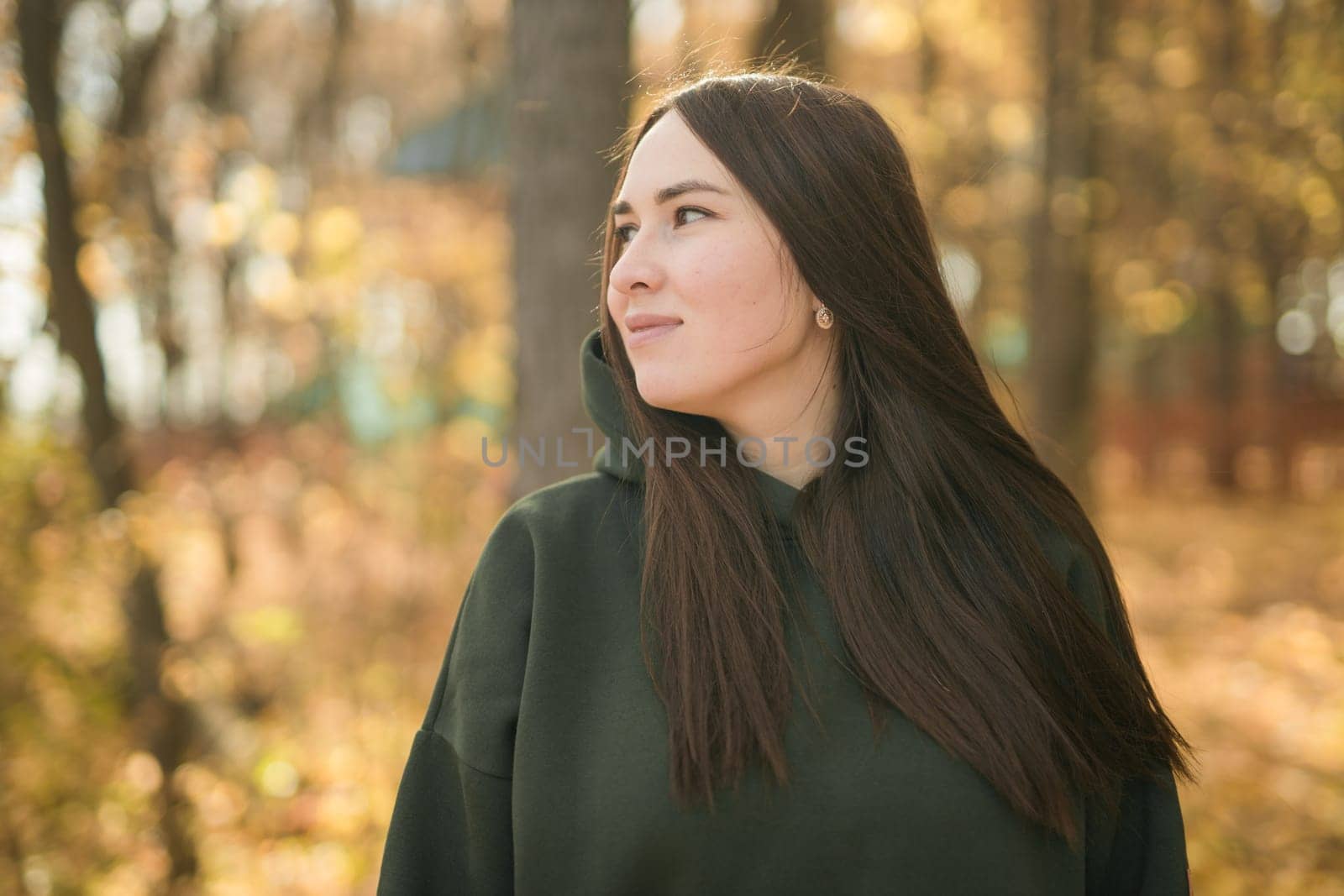 Beautiful smiling woman walking outdoors in autumn