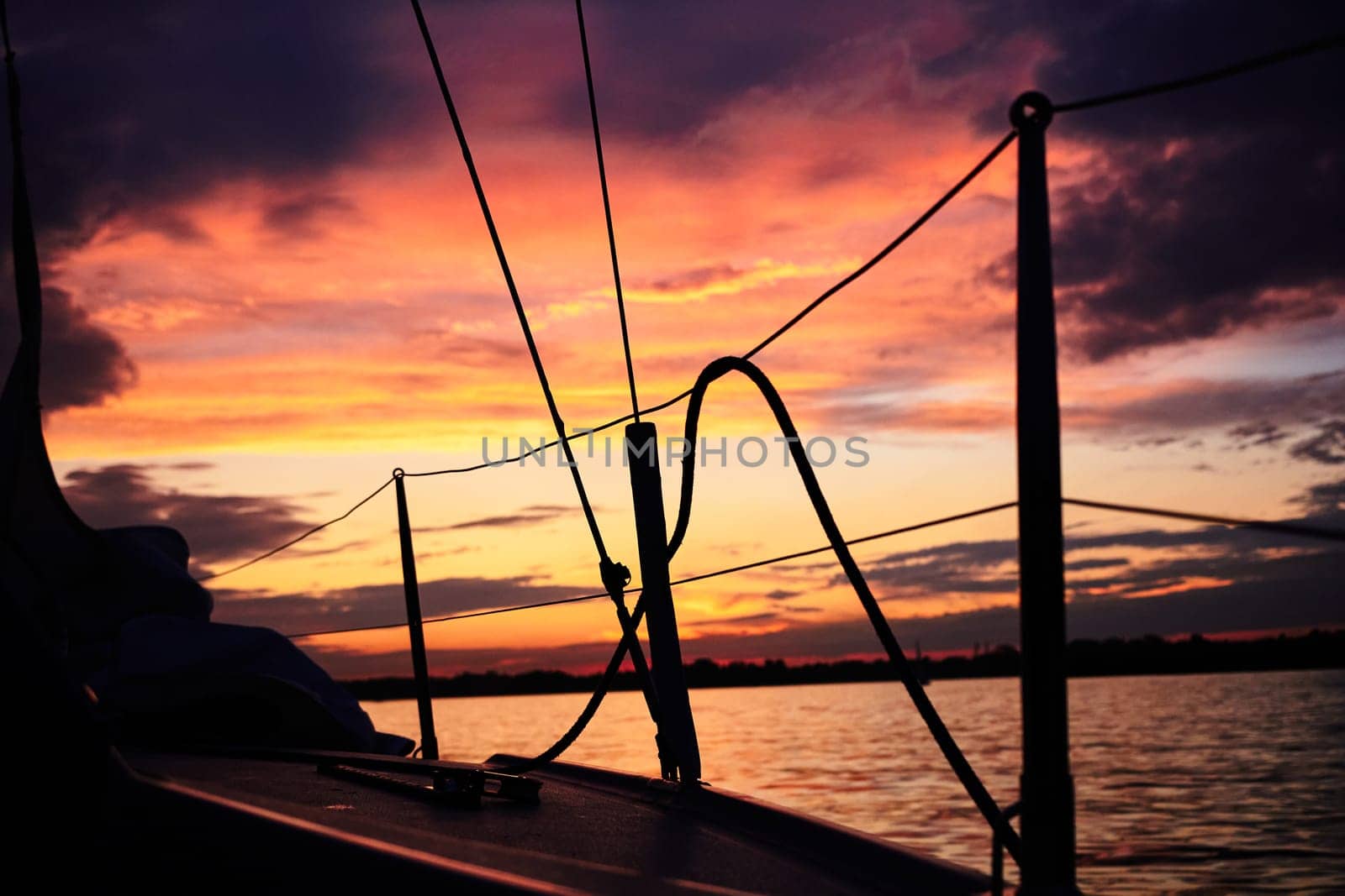 Photo of bright red sunset seen from yacht. Beautiful seascape.
