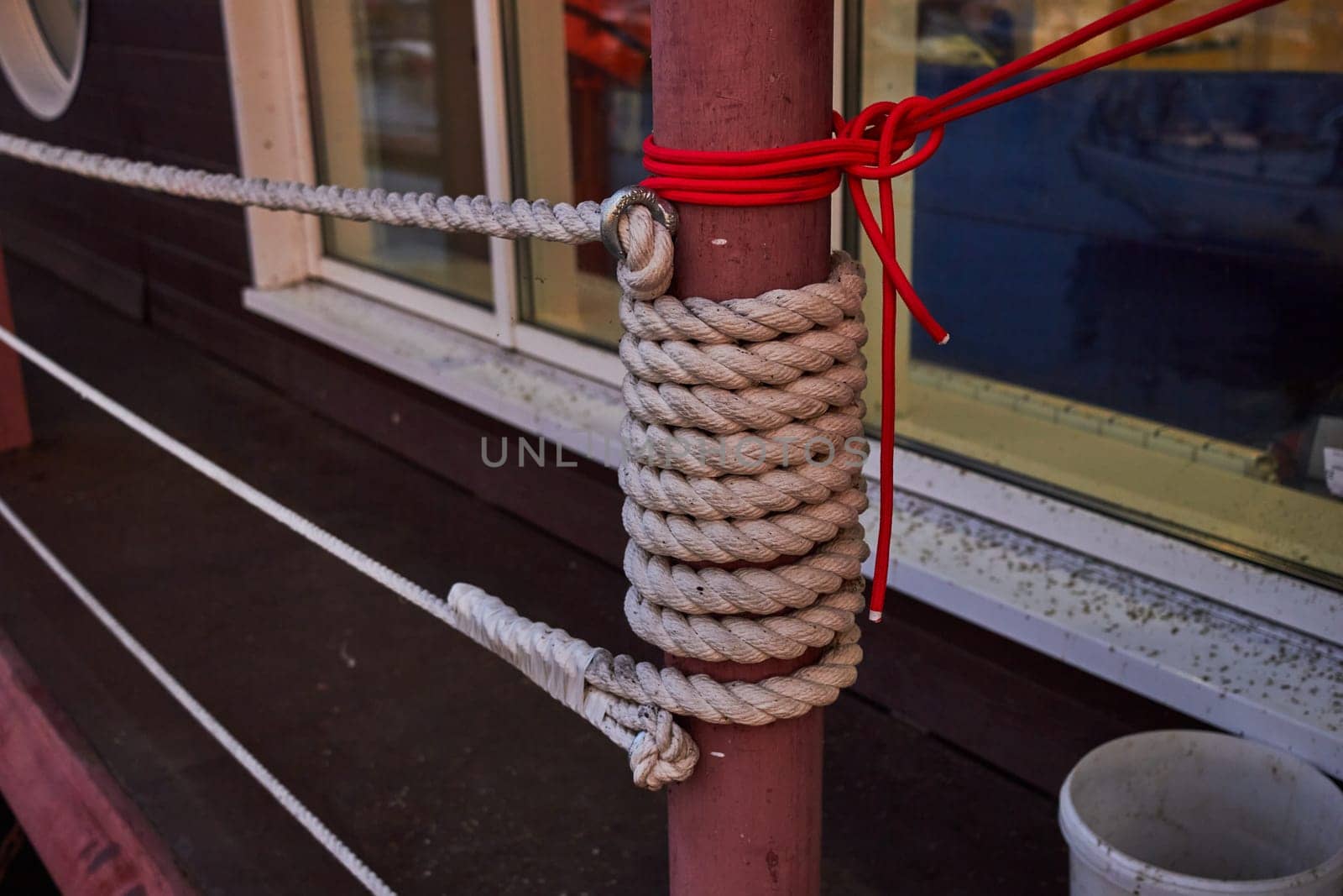 Photo of white twine rope wrapped around pipe. Wharf railings. Boat trips.